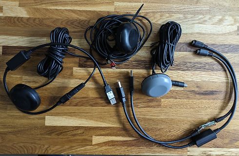 Diverse Kabel und schwarze Gehäuse auf Holzuntergrund