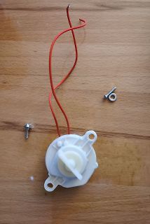 Schrittmotor mit roten Kabeln und zwei Schrauben