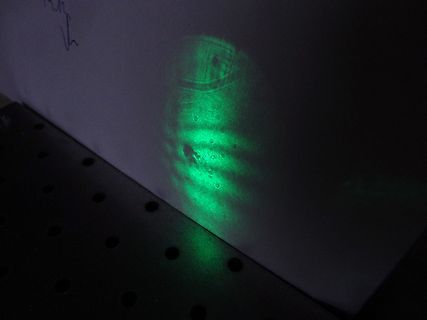 Grüner Laserstrahl auf weißer Fläche