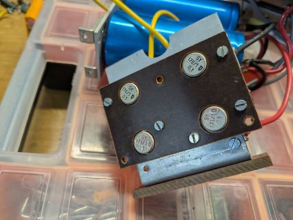 Elektronikbauteil mit vier Kondensatoren auf Platine