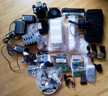 Verschiedene Elektronikbauteile, Netzteile und Platinen auf Holztisch