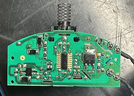 Grüne Leiterplatte mit Feder und elektronischen Bauteilen
