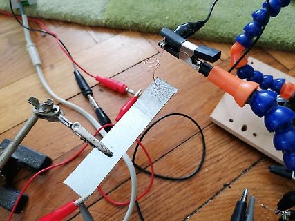 Elektrischer Aufbau mit Krokodilklemmen und Metallstreifen