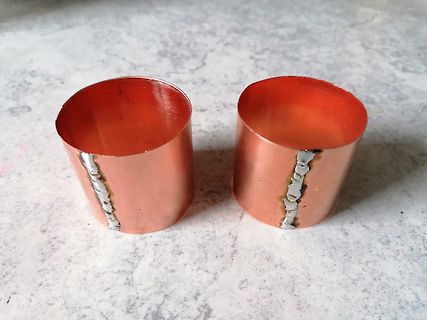 Zwei kupferfarbene Metallzylinder mit Schweißnähten