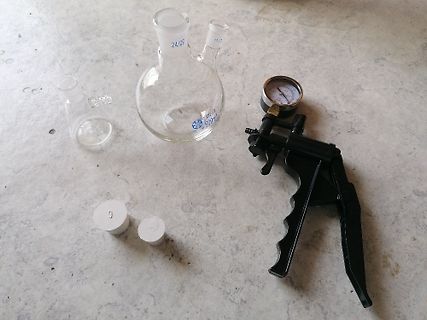 Laborausrüstung mit Kolben, Manometer und weißem Pulver