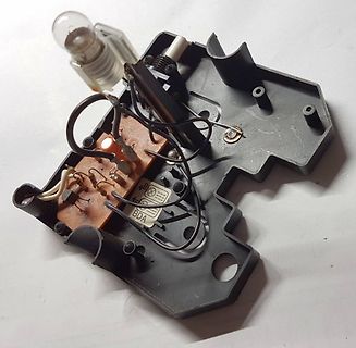 Innenansicht eines elektronischen Geräts mit Platine und Glühlampe