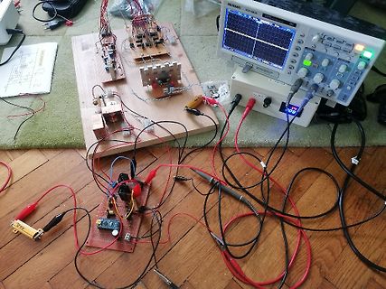 Elektronik-Versuchsaufbau mit Oszilloskop und Leiterplatten