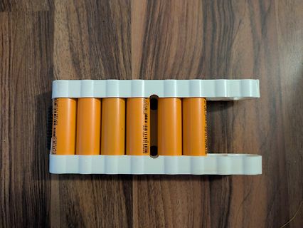 Sechs orangefarbene Batterien in weißem Halter