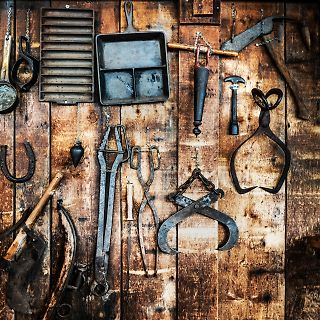 Alte Werkzeuge an einer Holzwand