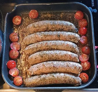 Würstchen mit Kirschtomaten in einer Pfanne