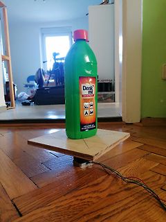 Grüne Flasche auf Holzbrett mit Kabeln
