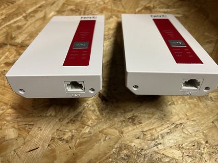 Zwei weiße FRITZ! WLAN Repeater auf Holzuntergrund