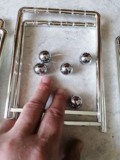 Metallrahmen mit silbernen Kugeln und Hand