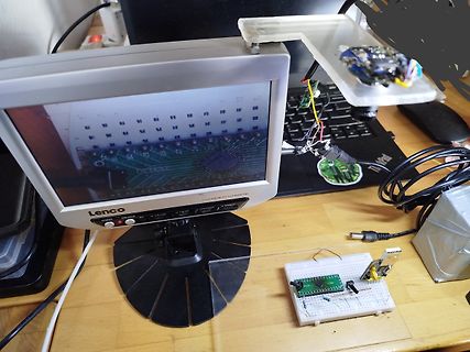 Elektronik-Aufbau mit Monitor, Breadboard und Leiterplatte