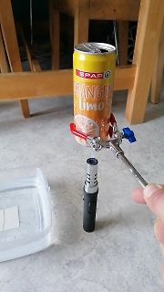 Dosenlimonade über einer Taschenlampe mit Klemme