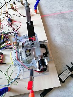 Experimenteller Aufbau mit Laser und Motoren auf Holzbrett