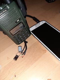 Funkgerät, Smartphone und Elektrolytkondensatoren auf Holztisch