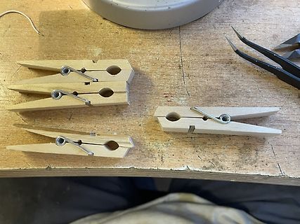 Holzwäscheklammern und Pinzette auf Werkbank