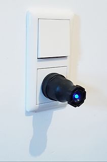 Netzstecker in Steckdose mit blau leuchtender LED