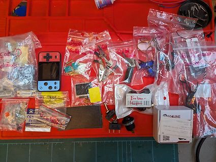 Elektronikbauteile und Kleinteile in Plastikbeuteln auf rotem Untergrund