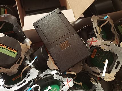 Elektronikkomponenten und Gehäuseteile in einer Kiste