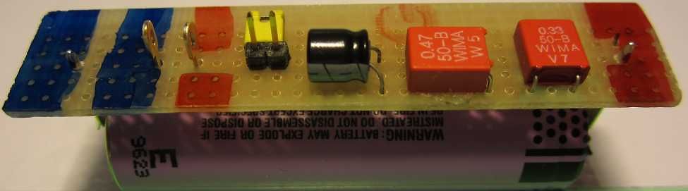 Elektronische Bauteile auf einer Platine über einer Batterie