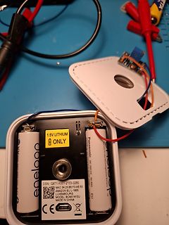 Geöffnetes Batteriefach mit Batterien und Kabeln