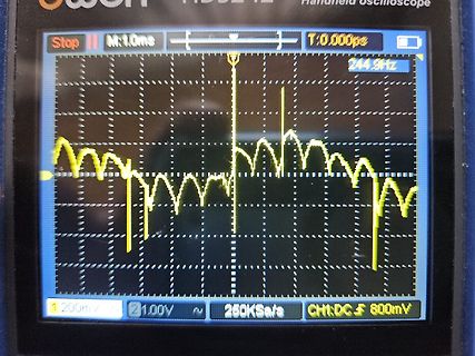 Abfotografierter Bildschirm eines Handheld-Oszilloskops mit Wellenform
