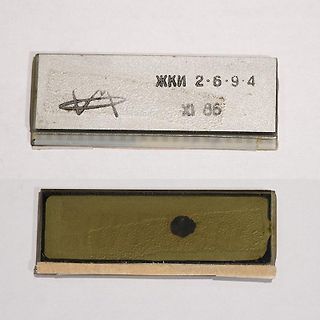 Zwei metallische Bauteile mit Beschriftung