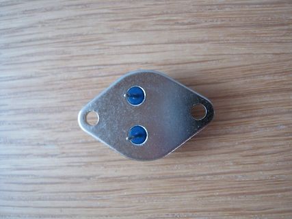 Metallplatte mit zwei blauen Bauteilen