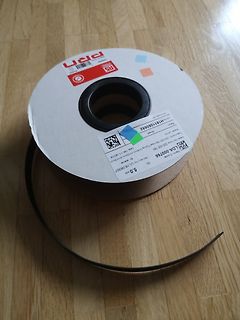 Spule mit schwarzem Band auf Holzboden