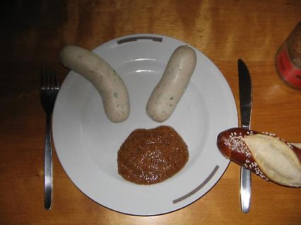 Teller mit Würstchen, Senf und Brötchen
