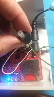 Hand hält Stecker über roter Leiterplatte