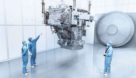 Techniker in Reinraum vor komplexer Maschine