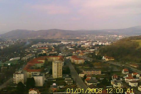 Luftaufnahme einer Stadtlandschaft mit Hügeln im Hintergrund