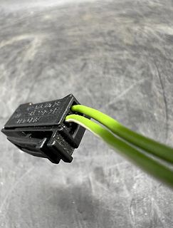 Elektrischer Stecker mit grünen Kabeln