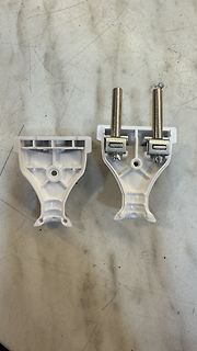 Zwei weiße Kunststoffhalterungen mit Metallstiften