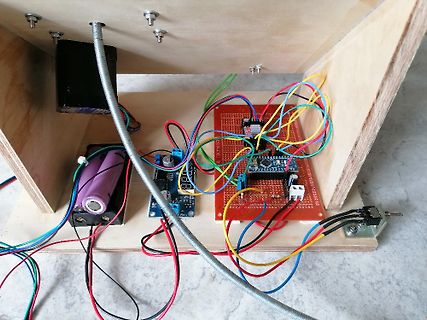 Elektronikaufbau mit Lochrasterplatine, Batterien und Verkabelung auf Holz