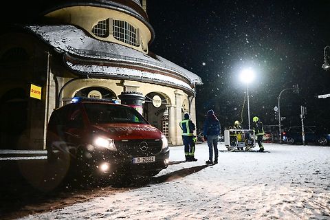 Rettungskräfte im Schnee vor einem Gebäude