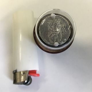Feuerzeug und ein rundes Bauteil mit Gitter