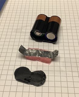 Zerlegte Batteriefachhalterung mit Batterien