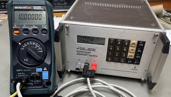 Multimeter und Kalibrationsquelle auf Werkstatt-Tisch