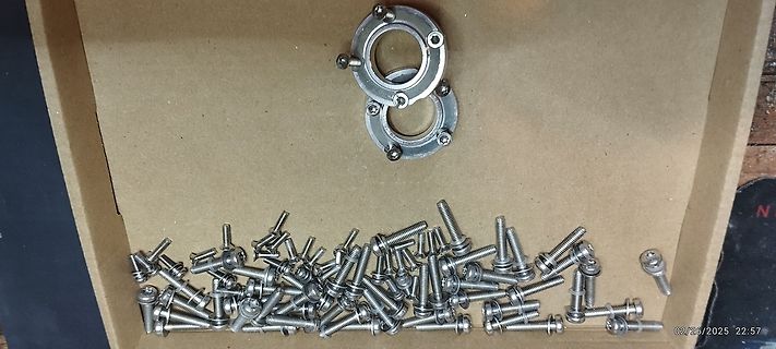 Schrauben und Metallringe in einem Karton