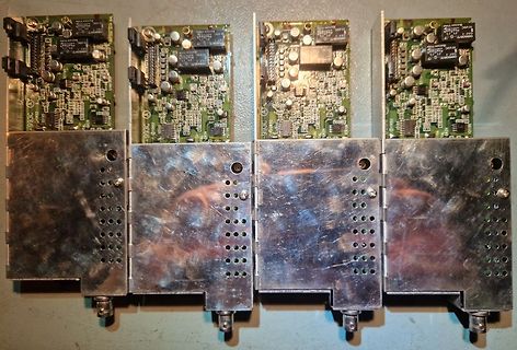 Vier identische Leiterplatten mit Metallgehäusen
