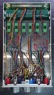 Innenansicht eines elektronischen Geräts mit Lochrasterplatine und Verdrahtung