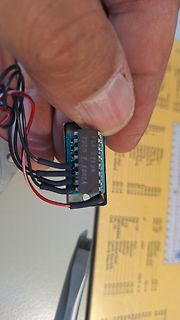 Hand hält elektronisches Bauteil mit Kabeln