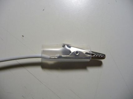 Krokodilklemme an weißem Kabel mit Isolierung