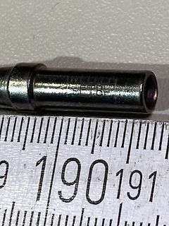 Nahaufnahme eines Metallbauteils mit Lineal