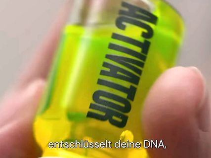 Hand hält Flasche mit gelber Flüssigkeit und Aufschrift