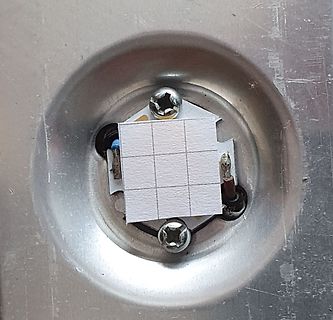 Nahaufnahme einer Metalloberfläche mit Bauteil und Klebestreifen